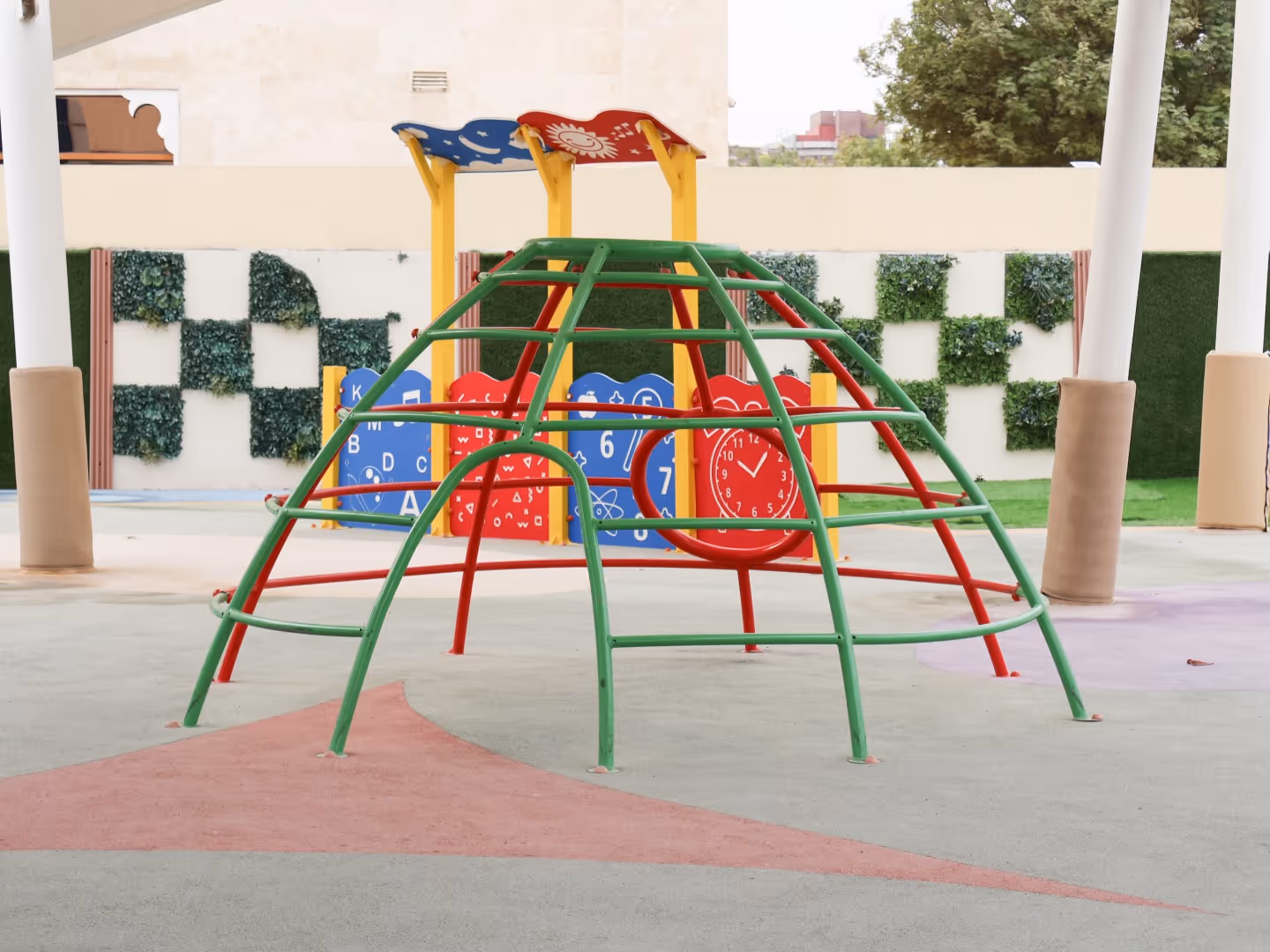 Colorful playground climbing dome with green and red bars and educational panels in the background.